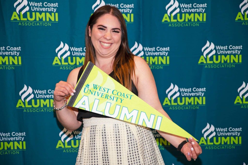 WCU BSN graduate Ashley Turbay holding WCU banner.