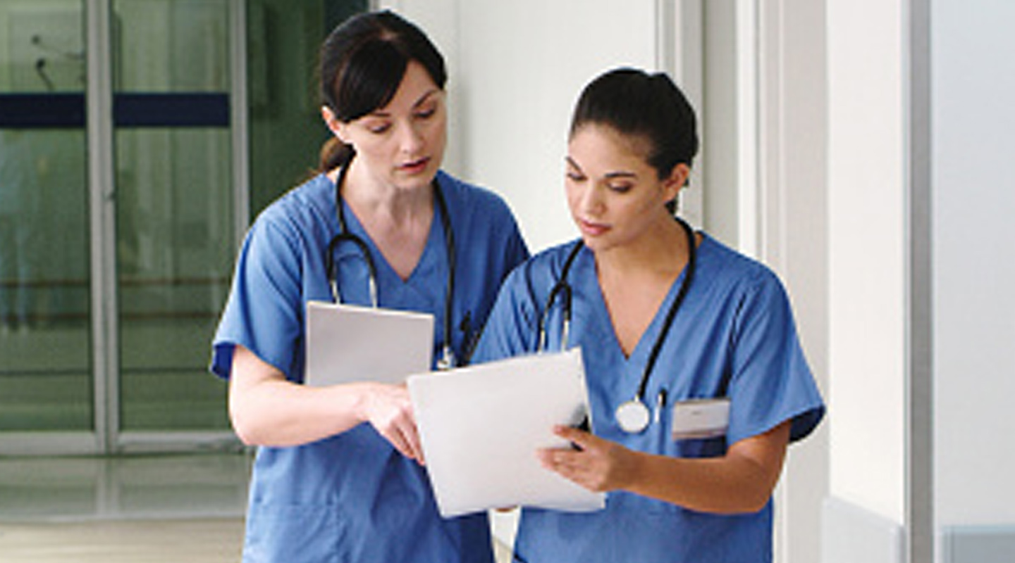 Two nurses looking at paperwork.