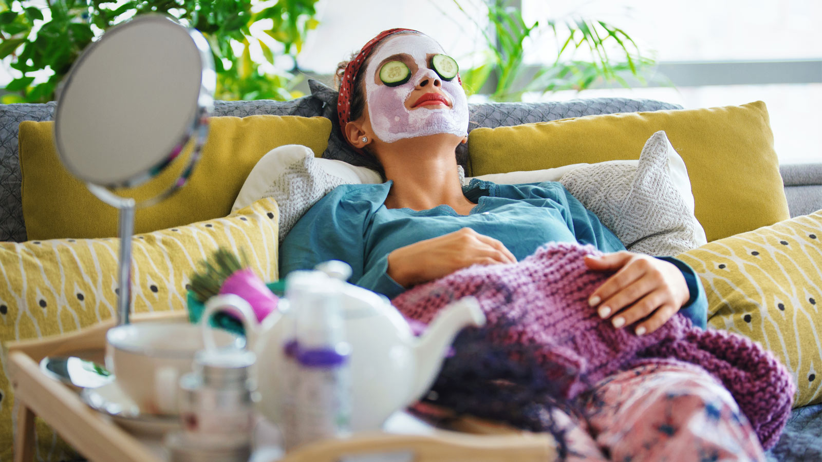 Woman relaxing on the couch while doing a facial.